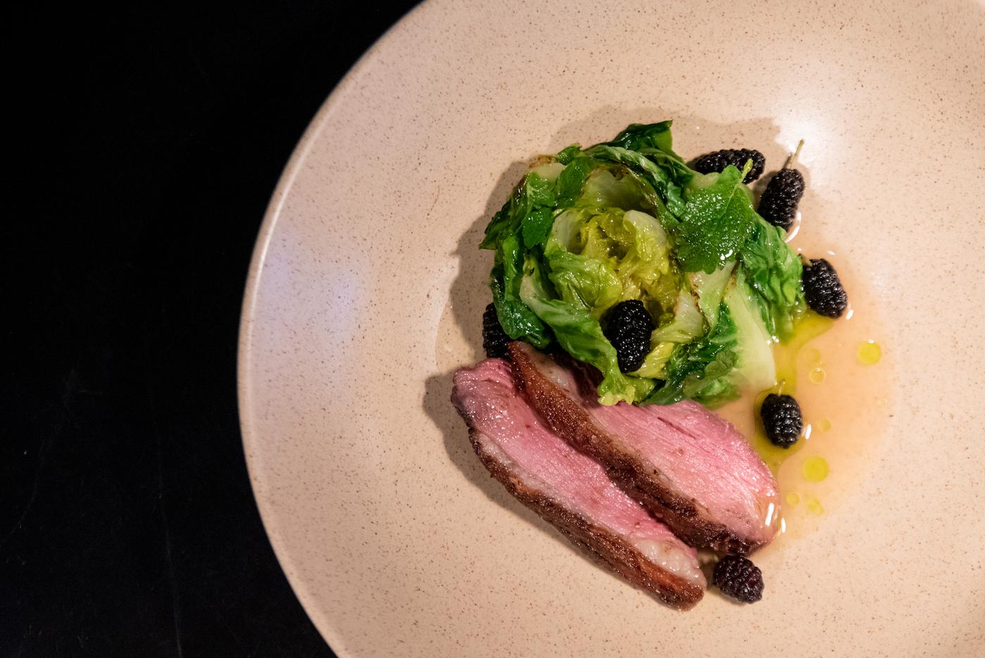 Magret duck with little gem lettuce and mulberries is served during the dinner service at Wherewithall at 3472 N. Elston Ave. in Chicago, Illinois. Photo: WTTW/Kathleen Hinkel