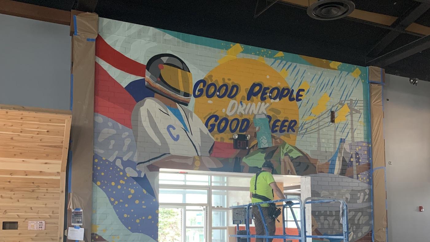 A worker and a mural inside the Wheeling District Brew Yards. Photo: Courtesy District Brew Yards