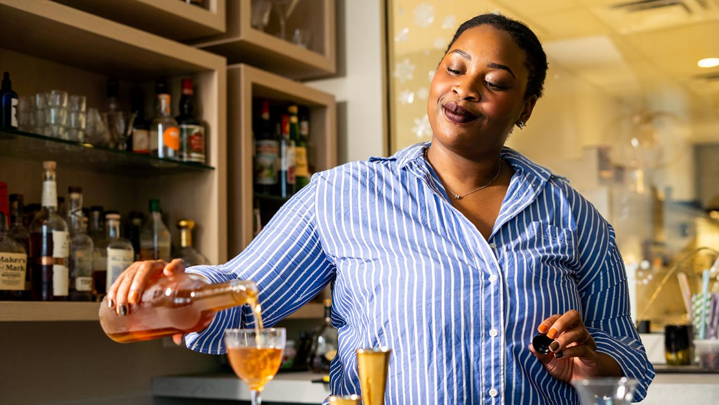 Tia Barrett, the beverage director and operations manager of Lincoln Park's Esmé, pours a drink
