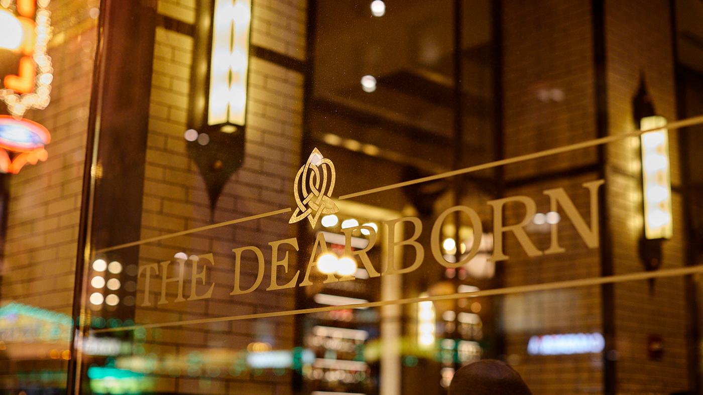 The Dearborn restaurant's logo and window at night in Chicago