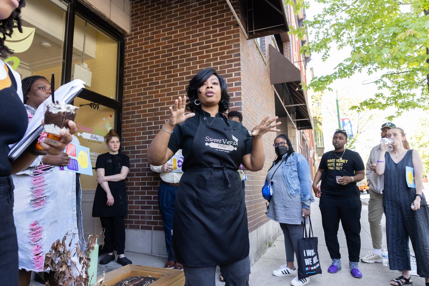 Cheryl Nelson of Sweet Vegan Bakes addresses a crowd outside her shop