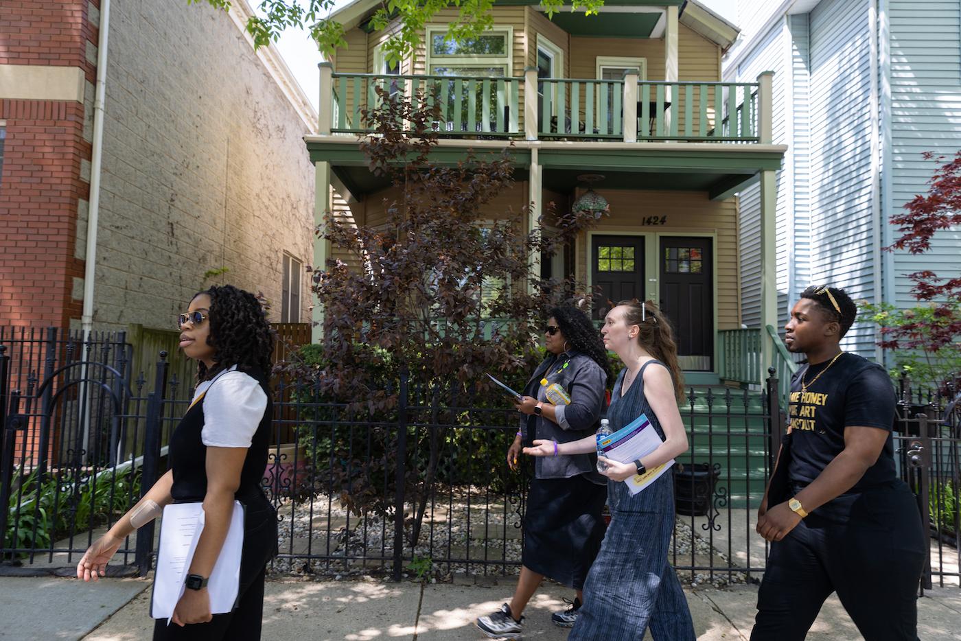 Tour participants walk past a house in Lincoln Park