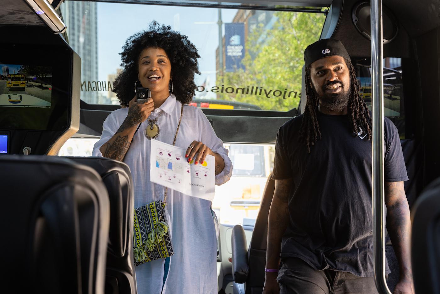 Tonika Lewis Johnson and Shermann "Dilla" Thomas stand at the front of a tour bus