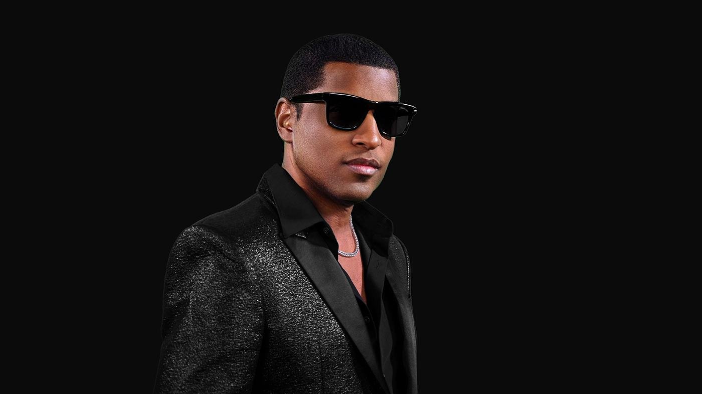 Babyface poses in sunglasses in front of a black background
