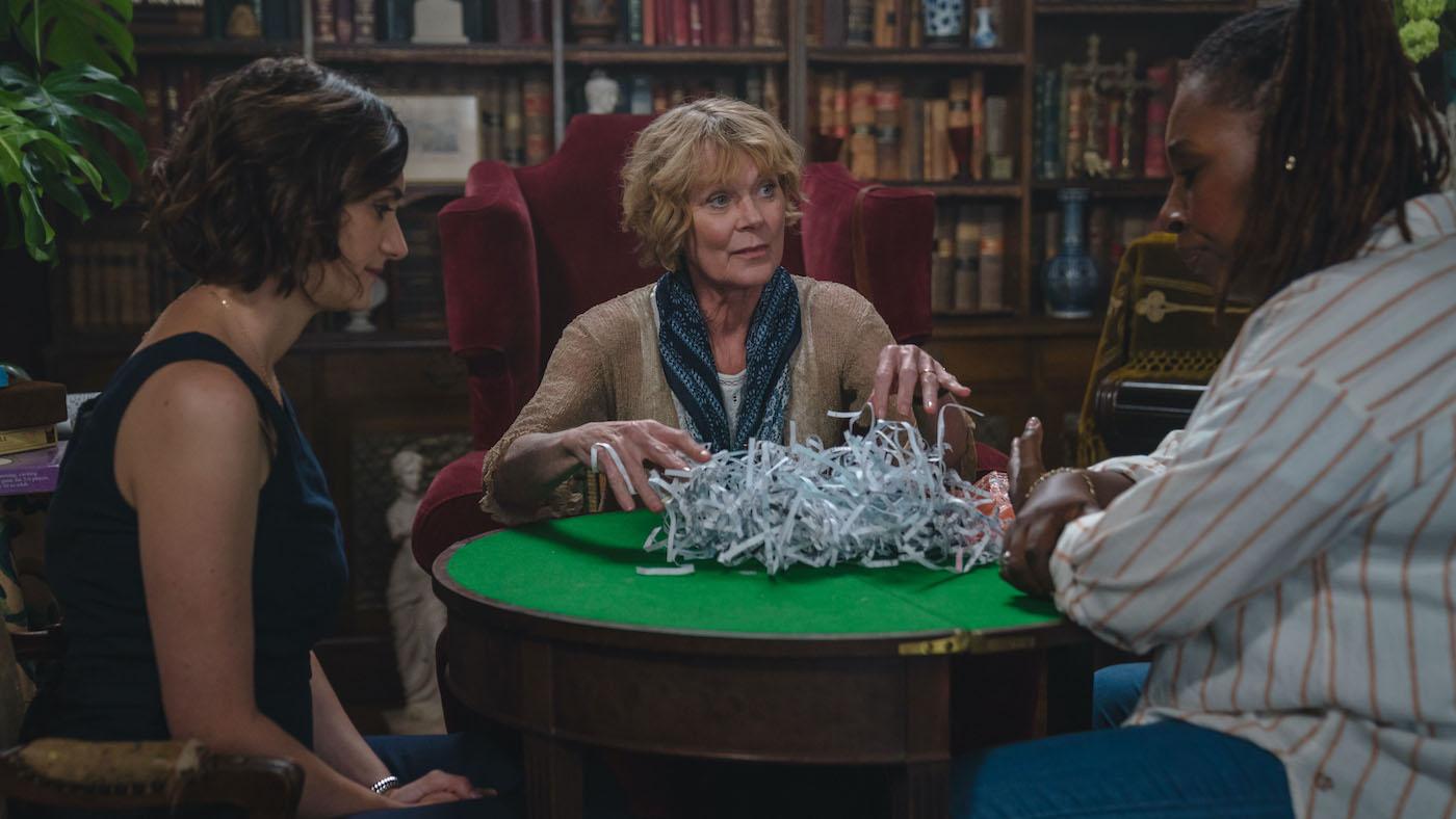 Becks Starling, Judith Potts, and Suzie Harris sit around a table with shredded paper on it