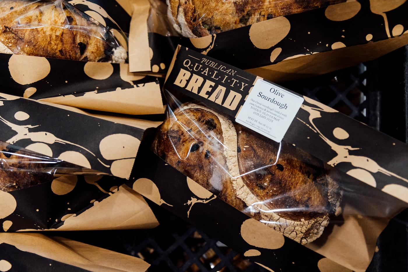 Loaves of Publican Quality Bread in packaging lie on top of each other