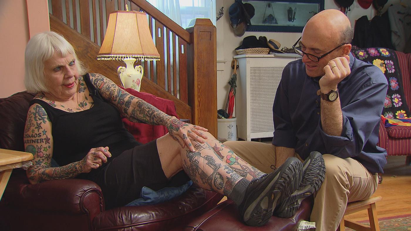 Helen Lambin shows Jay Shefsky her collection of tattoos