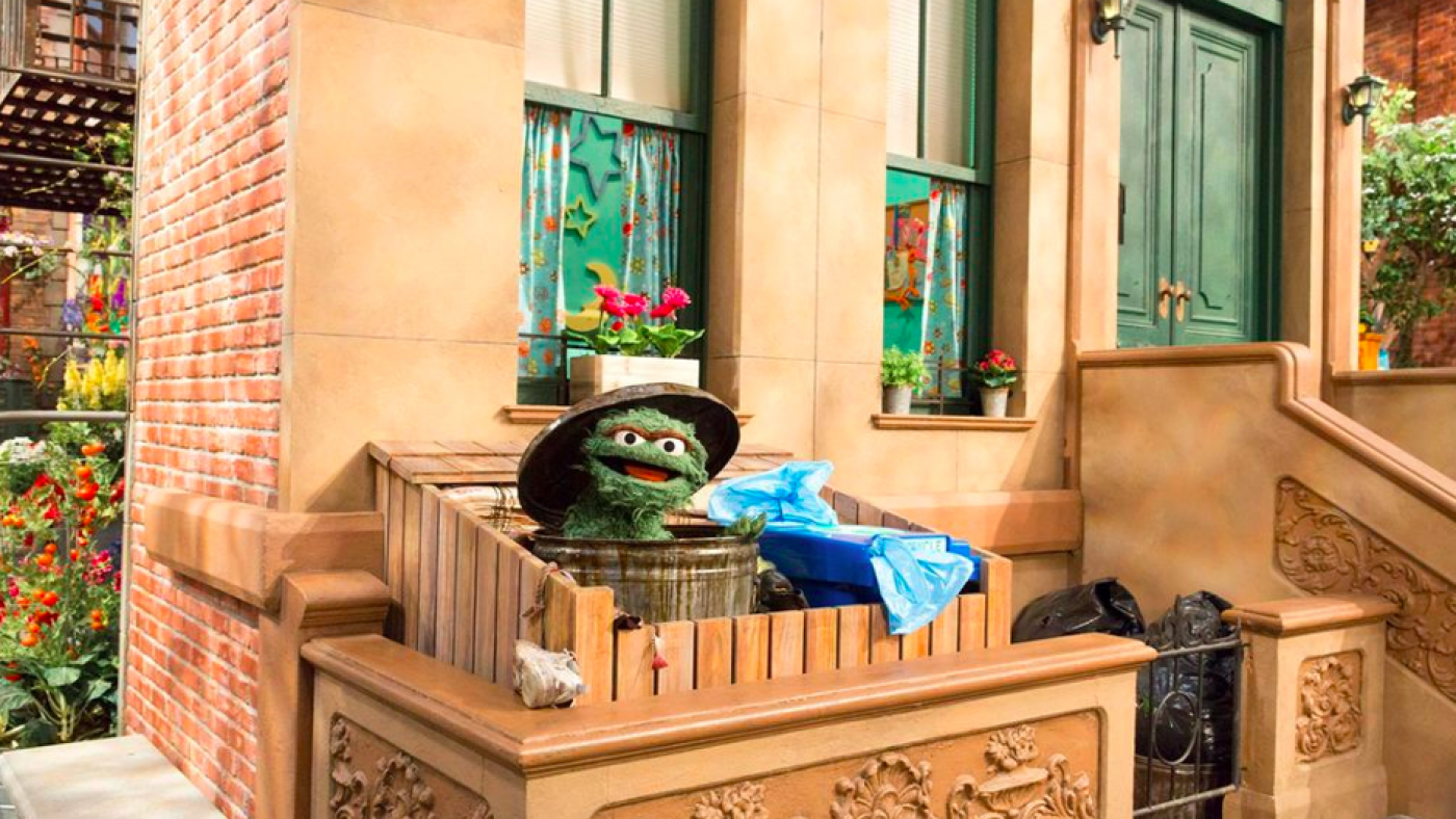 Oscar the Grouch by a recycling bin. Photo: Sesame Workshop