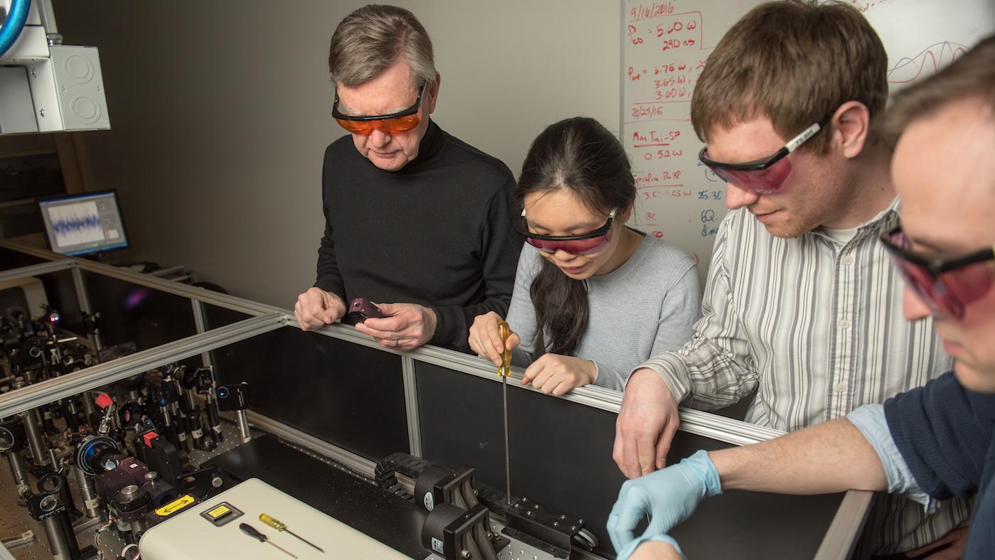 Northwestern Professor Michael R. Wasielewski works with students to tune an ultrafast laser system used for solar energy research. Photo: Institute for Sustainability and Energy at Northwestern University 