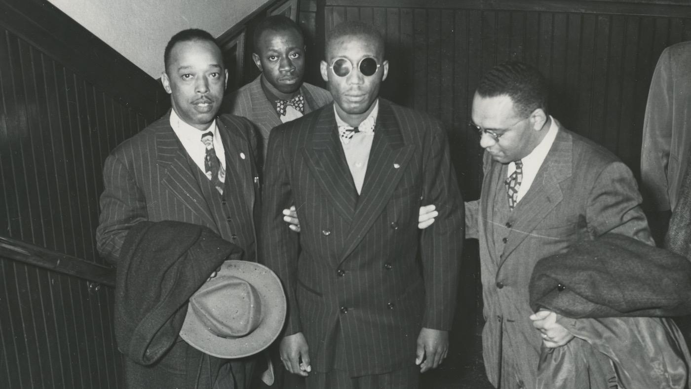 Leroy Carter, Isaac Woodard, and Donald Jones, NAACP assistant field secretary. Willie Mabry, Sgt. Woodard’s cousin. in background. Likely taken while Woodard was on his speaking tour with the NAACP. 10/1946. Photo: AFRO American Newspapers Archives