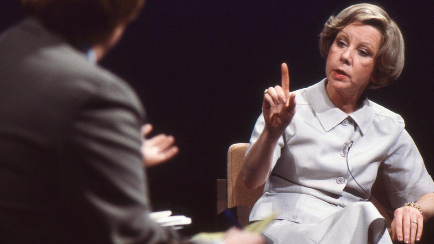 Jane Byrne raising her finger while speaking at a mayoral forum