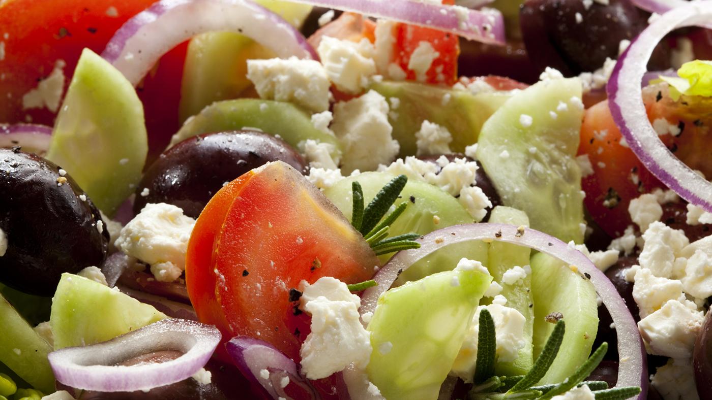 A Greek salad with tomatoes, cucumbers, red onion, and Kalamata olives.