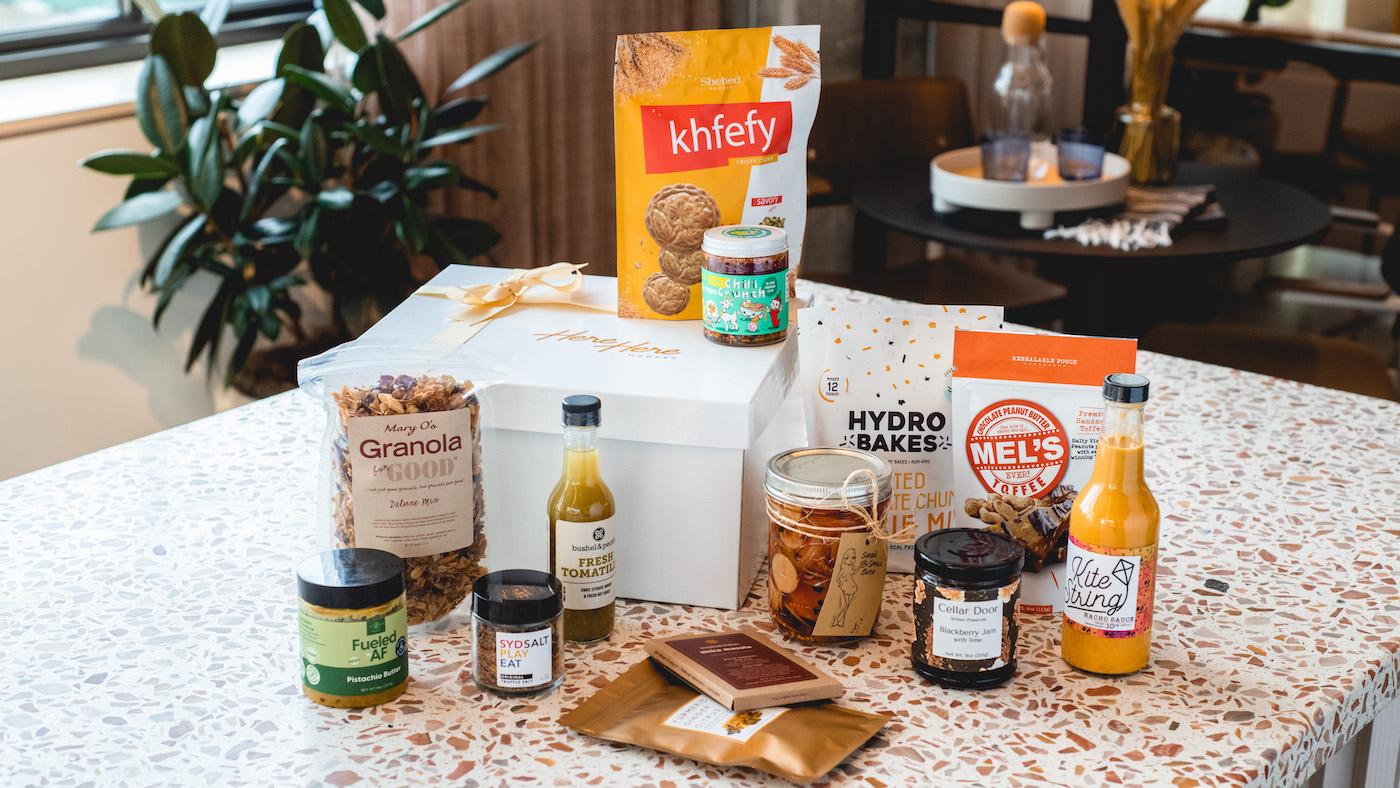A gift box from Here Here Market featuring various products made by Chicago food chefs and entrepreneurs