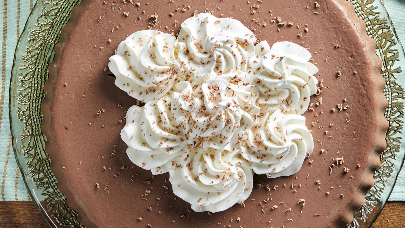 A chocolate blancmange topped with whipped cream and spices