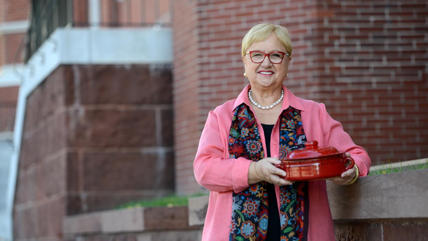 Lidia Bastianich holding a pot with her escarole and white bean soup