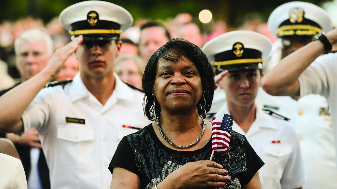 An audience member stands for the national anthem at a previous broadcast of the National Memorial Day Concert.
