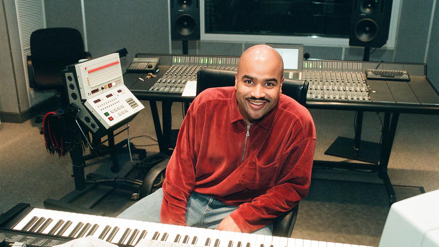 DJ Steve "Silk" Hurley sits behind a keyboard and in front of a mixing board in a studio in 1996