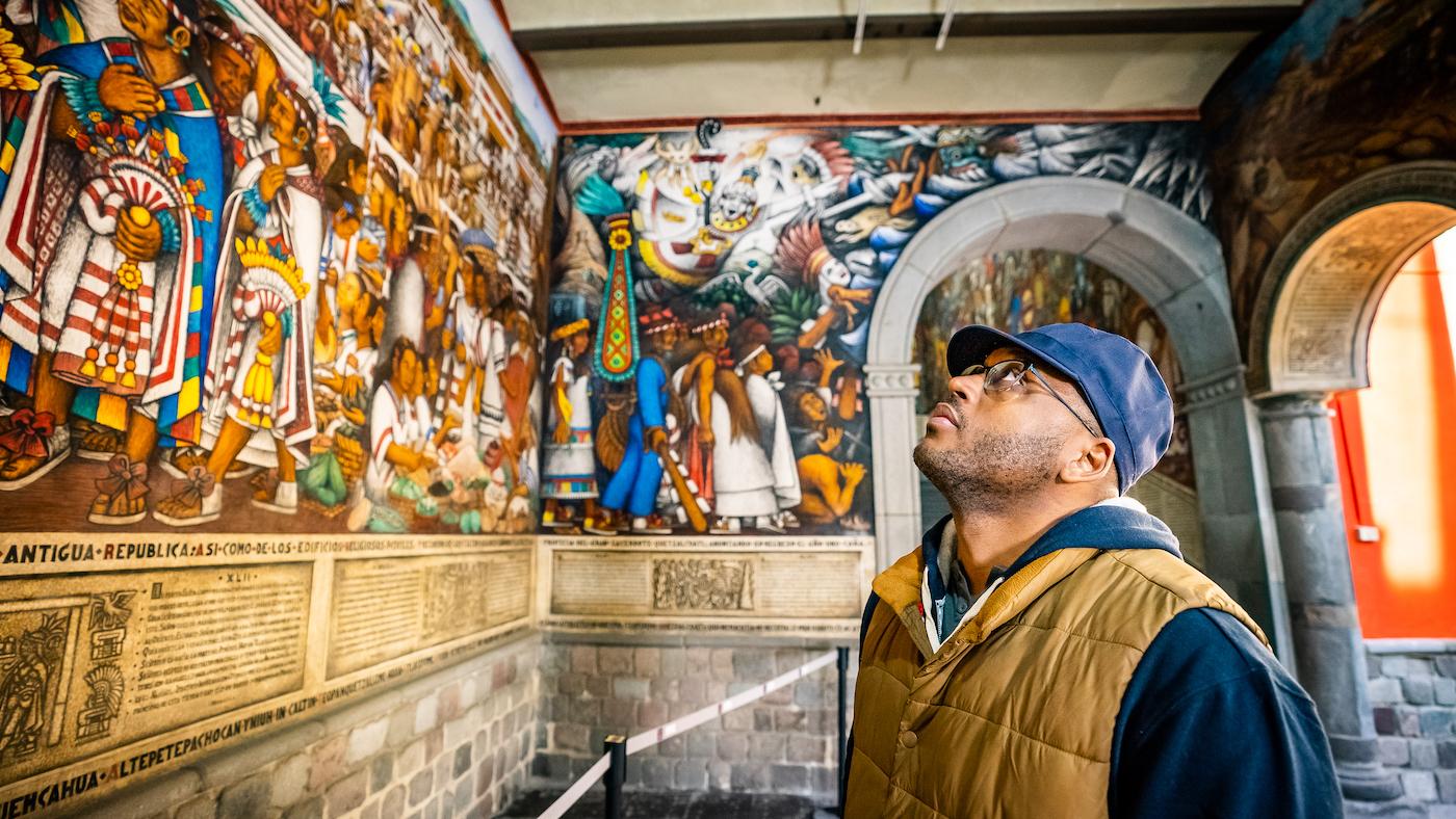 Shane Campbell-Staton looks up at a mural at the palace of the governor in Tlaxcala, Mexico