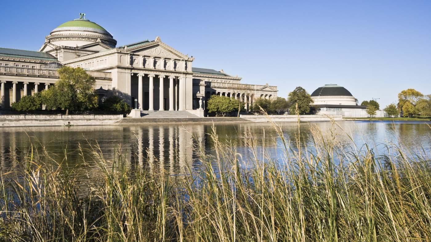 The exterior of the Museum of Science and Industry with a pond in the foreground