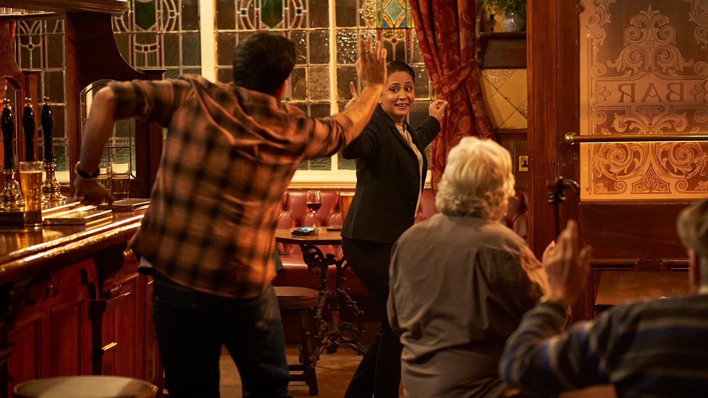 Tony Khatri and D.I. Ray do a Bollywood dance together in a pub while other people watch and clap