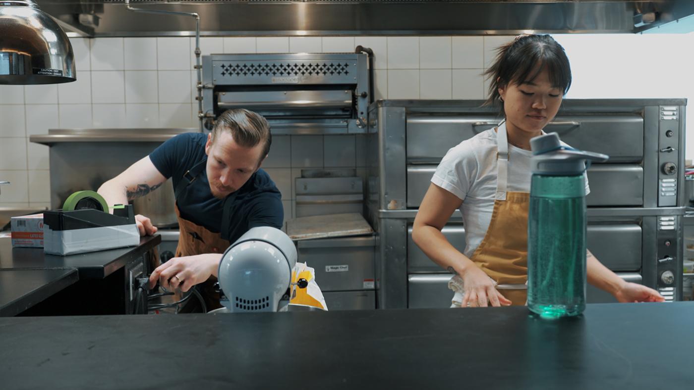 Mike Alesi and Jennifer Pou-Alesi work in a kitchen