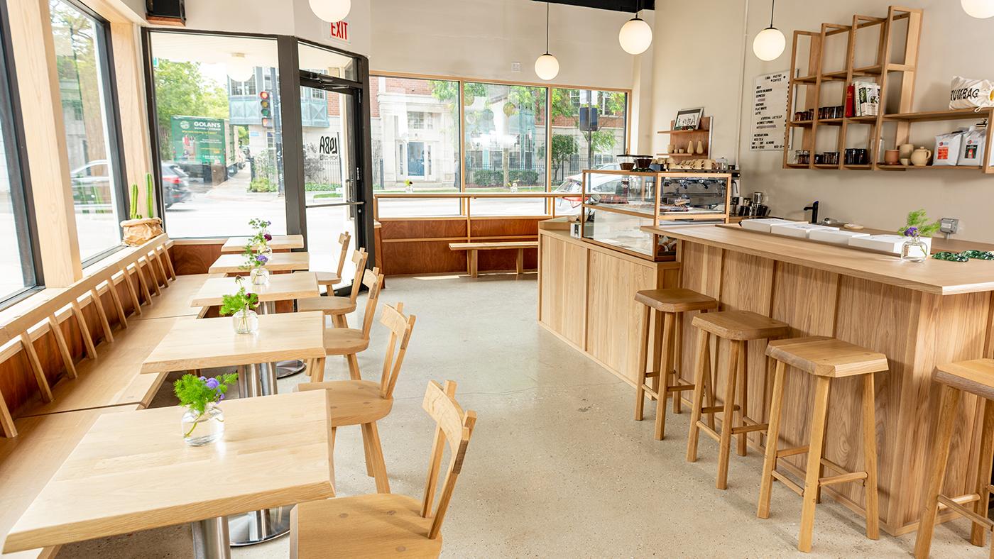 The blond wood interior of Loba Pastry, with tables and a bar and pastry case