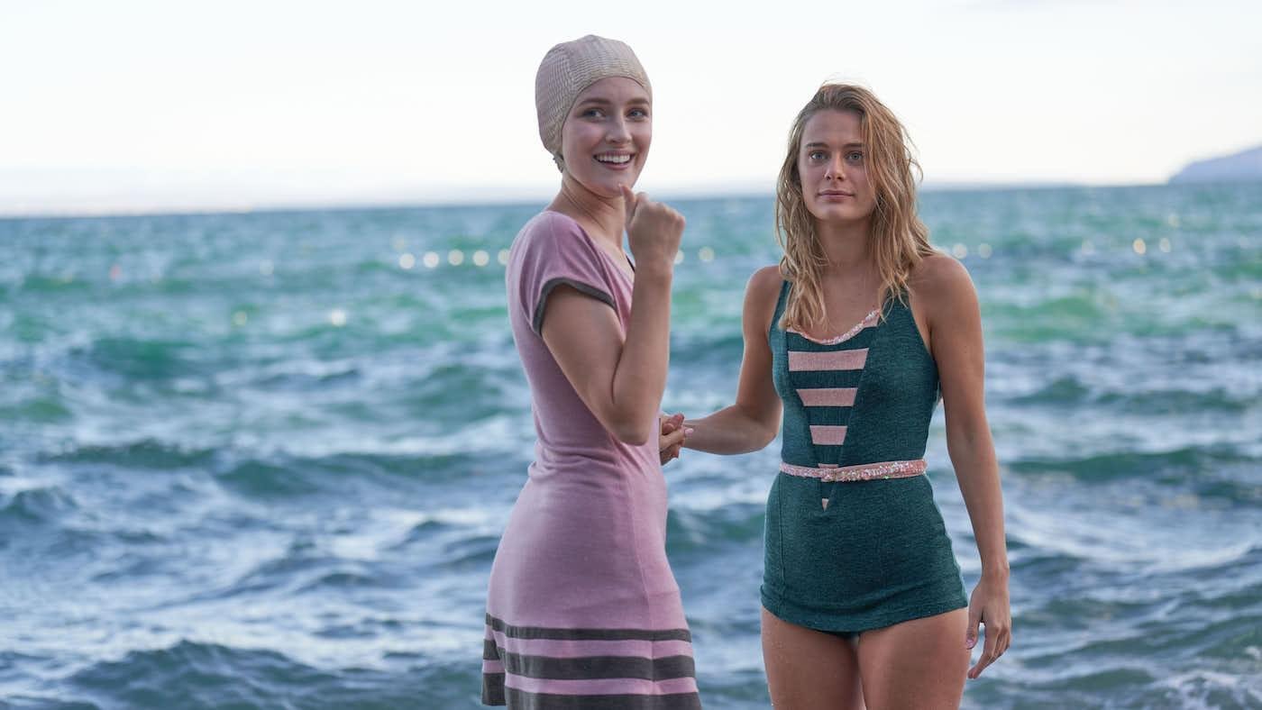 Rose and Constance stand by the ocean in bathing suits