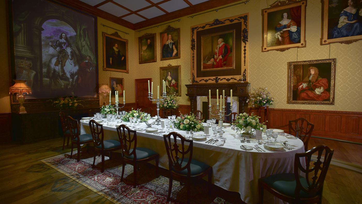 The upstairs dining room set from Downton Abbey contains a set table and portraits on the walls