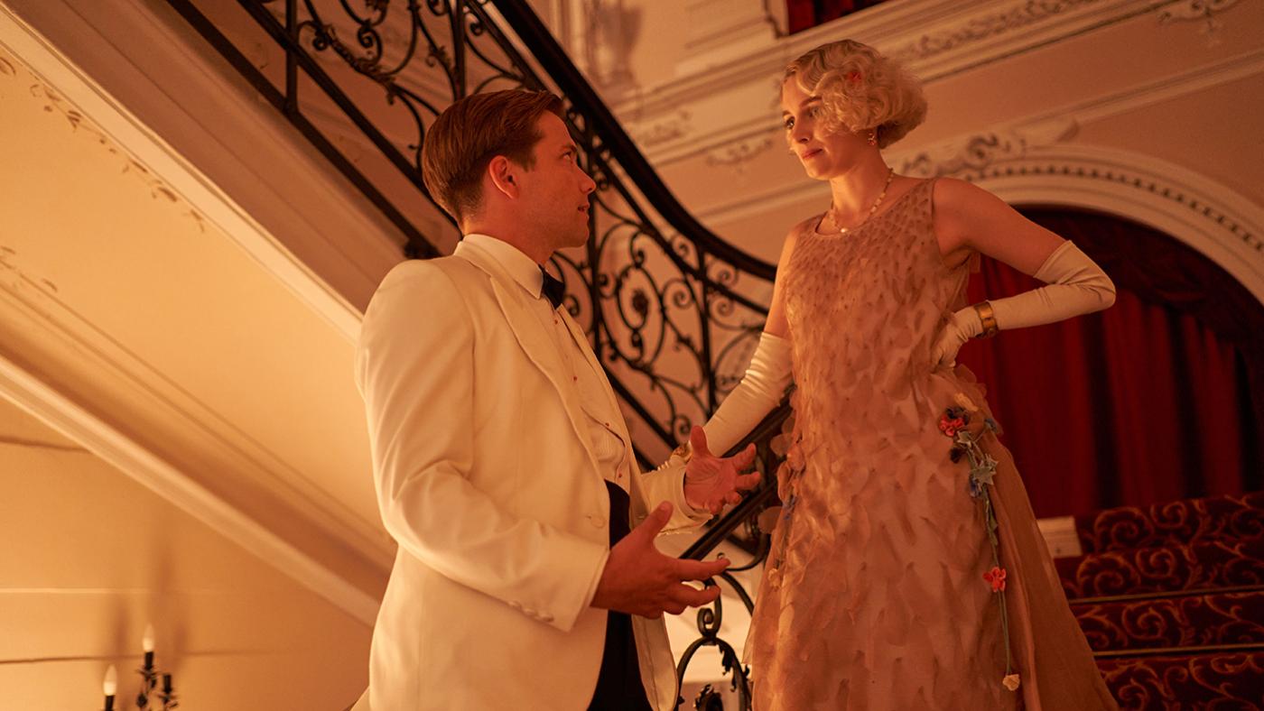 Lucian and Rose stand on a staircase in evening dress