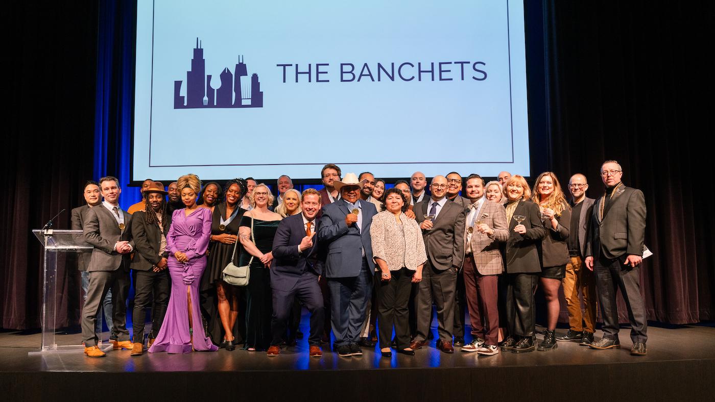 The winners of the Jean Banchet Awards pose onstage under a screen that says The Banchets