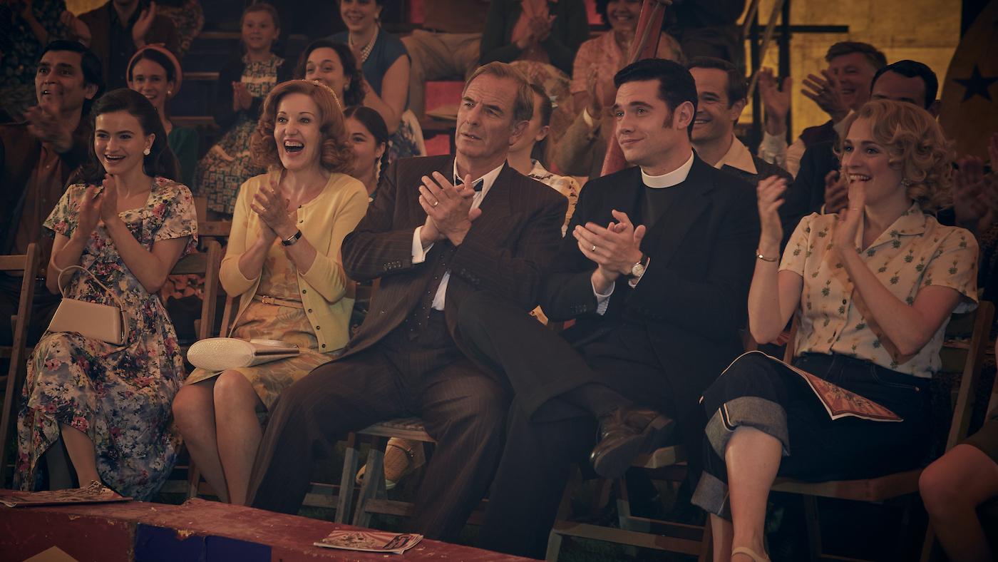 Esme, Cathy, Geordie, Will, and Bonnie clap in the front row of a circus 