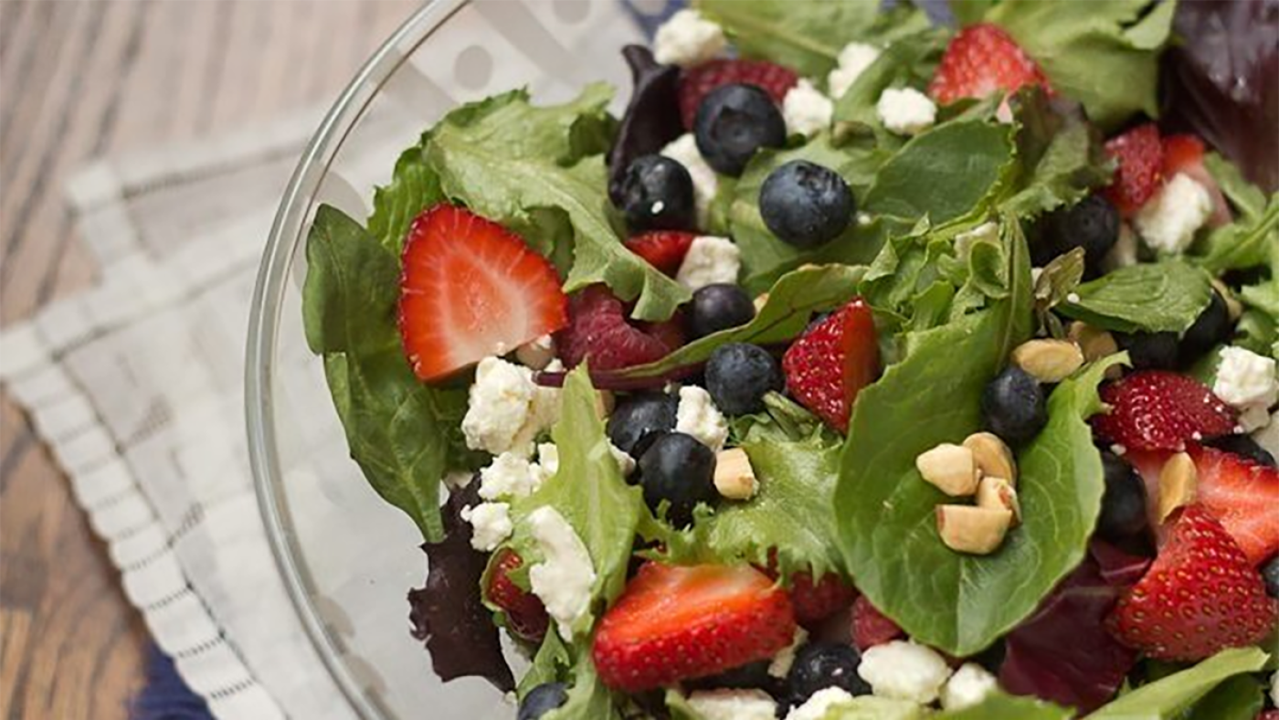A salad of berries, nuts, and cheese