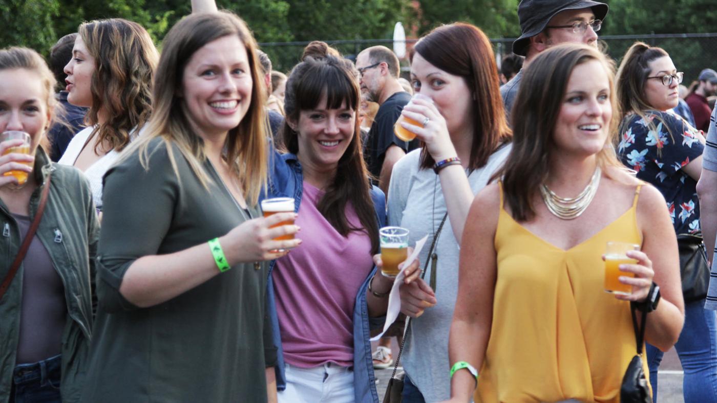 Women standing in Horner Park holding glasses of beer