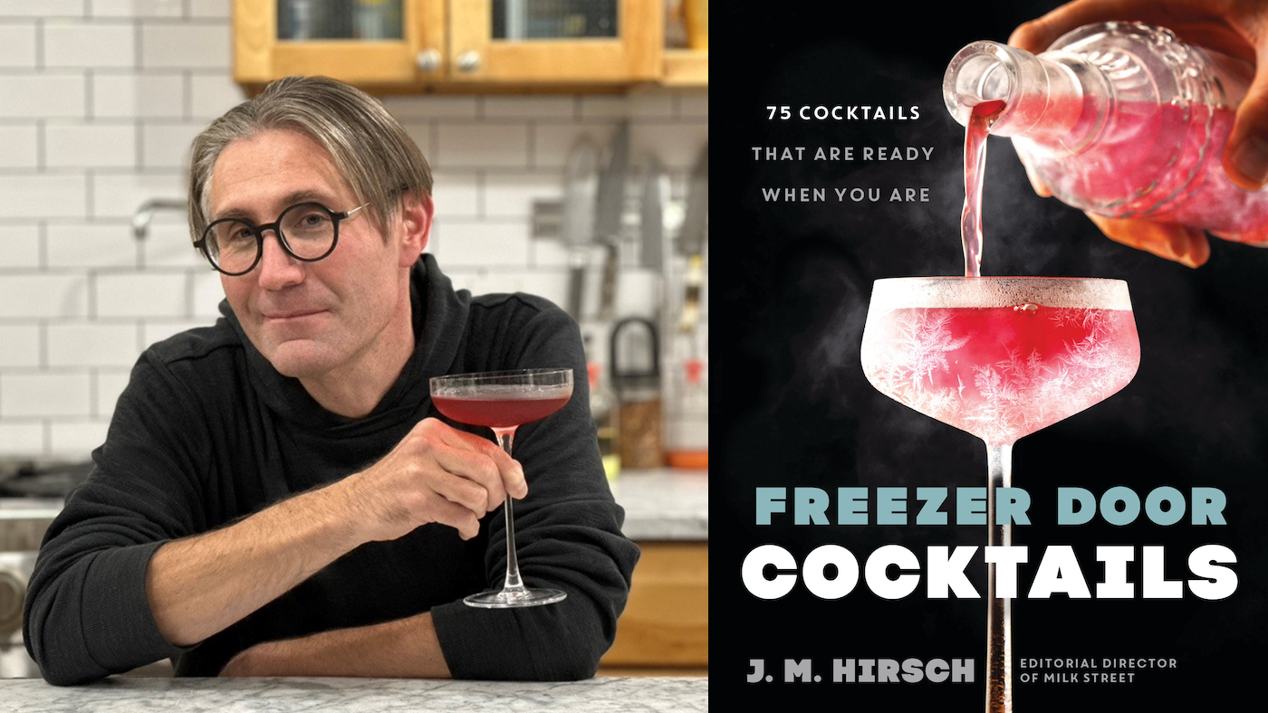 JM Hirsch holds a cocktail and smiles next to an image of his Freezer Door Cocktails book