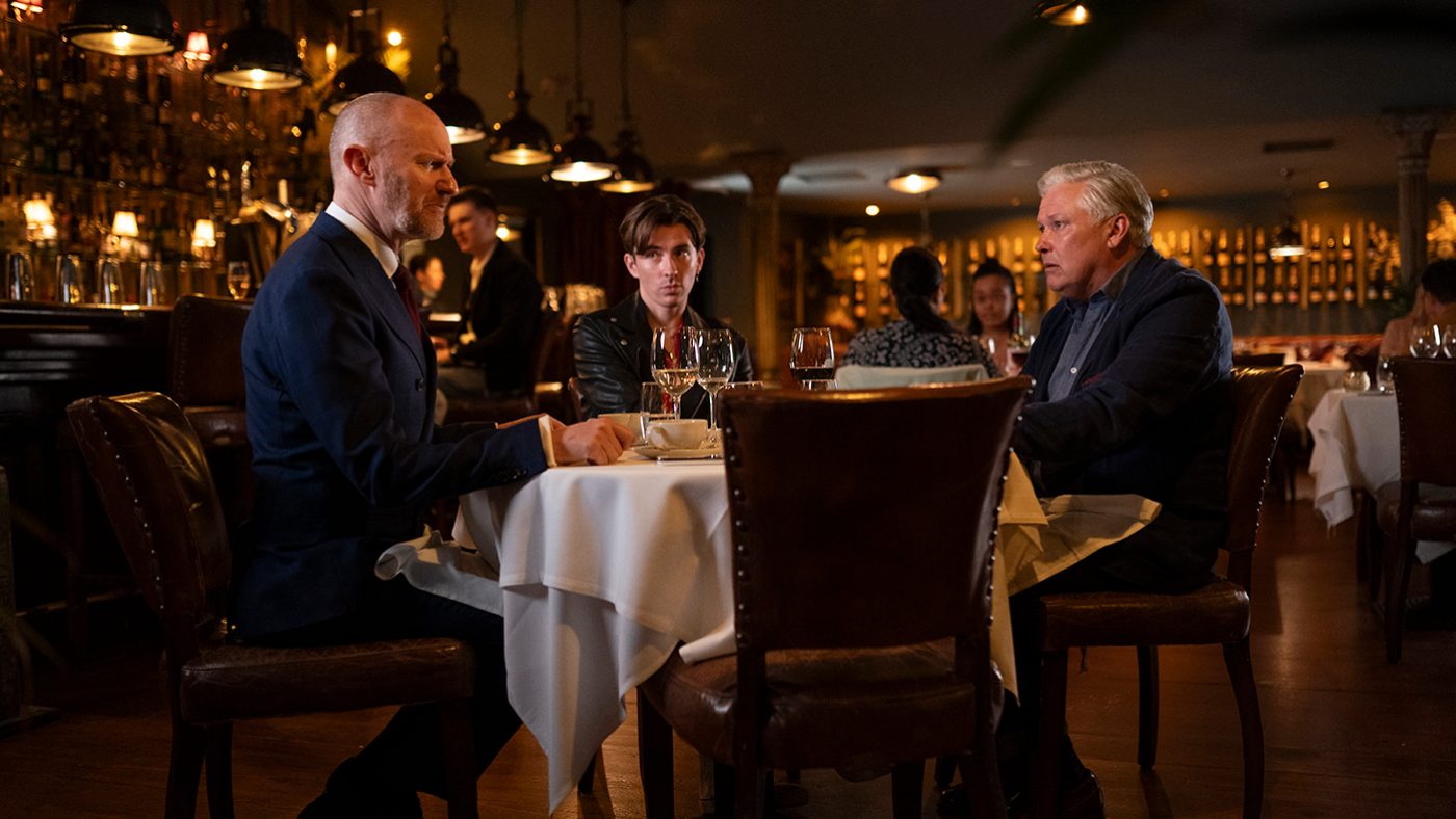 Frank Parris sits at a table in a restaurant with James Taylor and Alan Conway