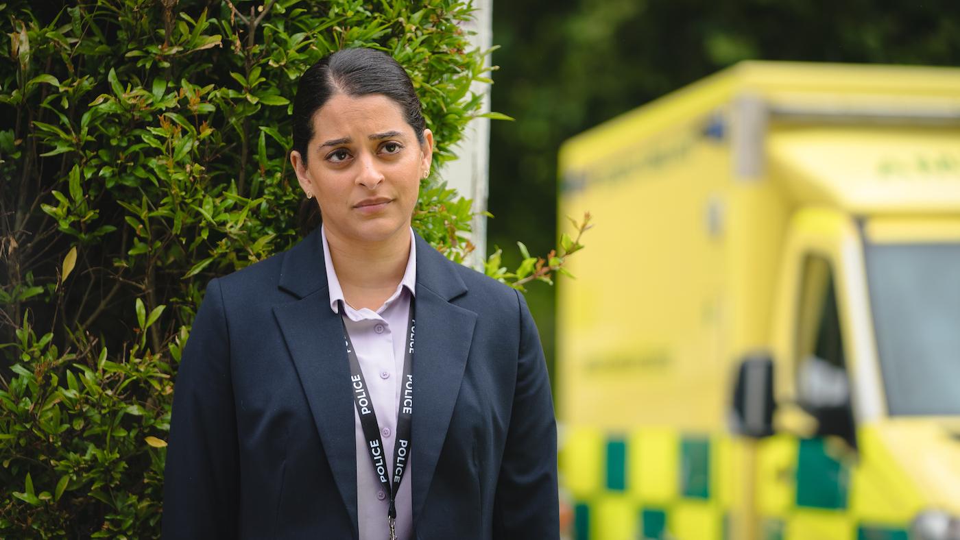 Tanika stands near a yellow ambulance