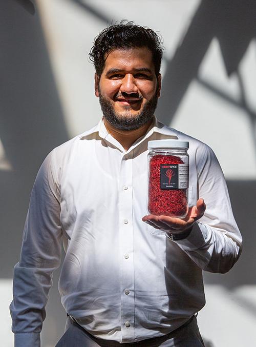 Mohammad Salehi holding a container of saffron.