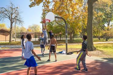 Kids play basketball at Oakdale Park in Washington Heights.