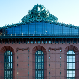 The red brick facade of the Harold Washington Library, with its glass gable and oversized ornaments