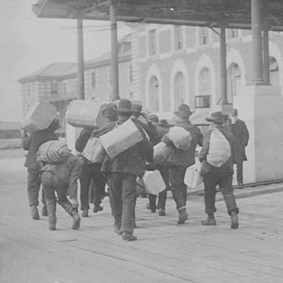 Immigrants carrying luggage, Ellis Island, New York. Photo: Courtesy Library of Congress