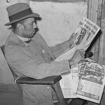 Tenant farmer reading newspaper. Creek County, Oklahoma. February 1940. Photo: Courtesy Library of Congress
