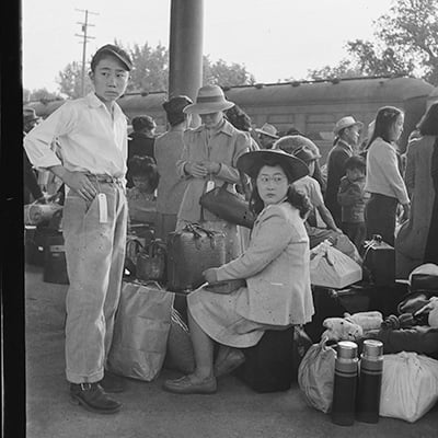 Japanese families in Woodland, California wait for train at railroad station to take them to internment camp. May 20 1942.
                Photo: Courtesy National Archives and Records Administration